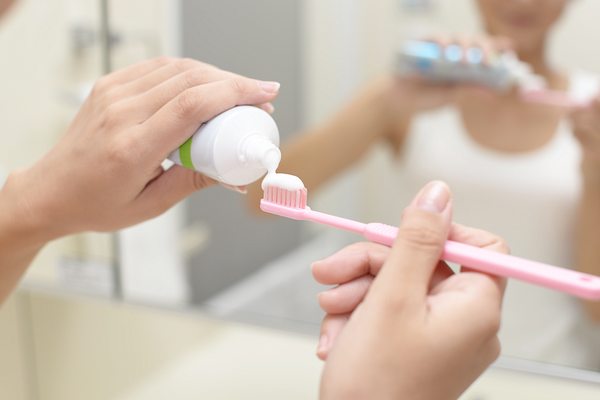 歯ブラシに歯磨き粉を出す女性